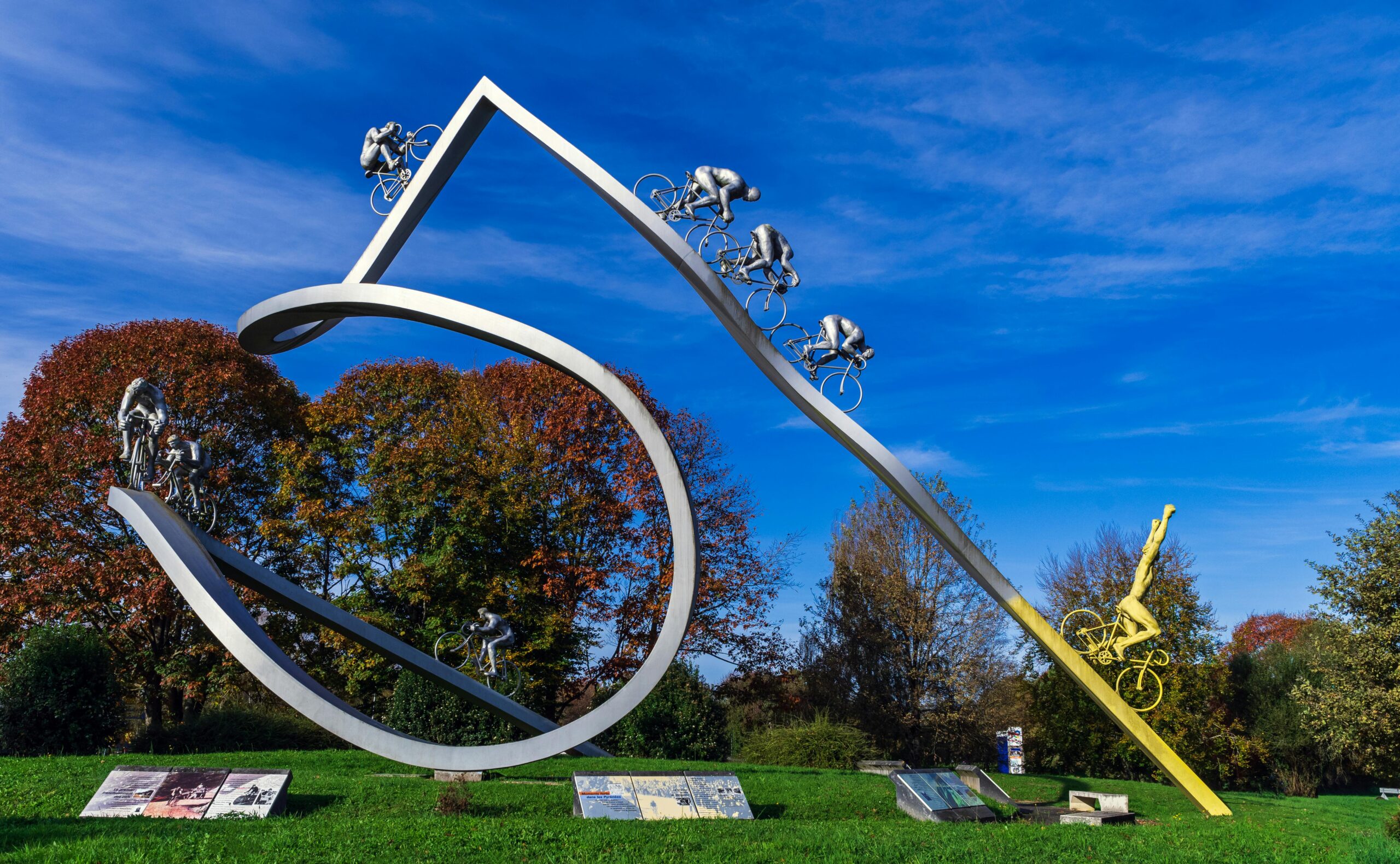 Skulptur von Radfahrern vor einem blauen Herbsthimmel in Ger, Frankreich.